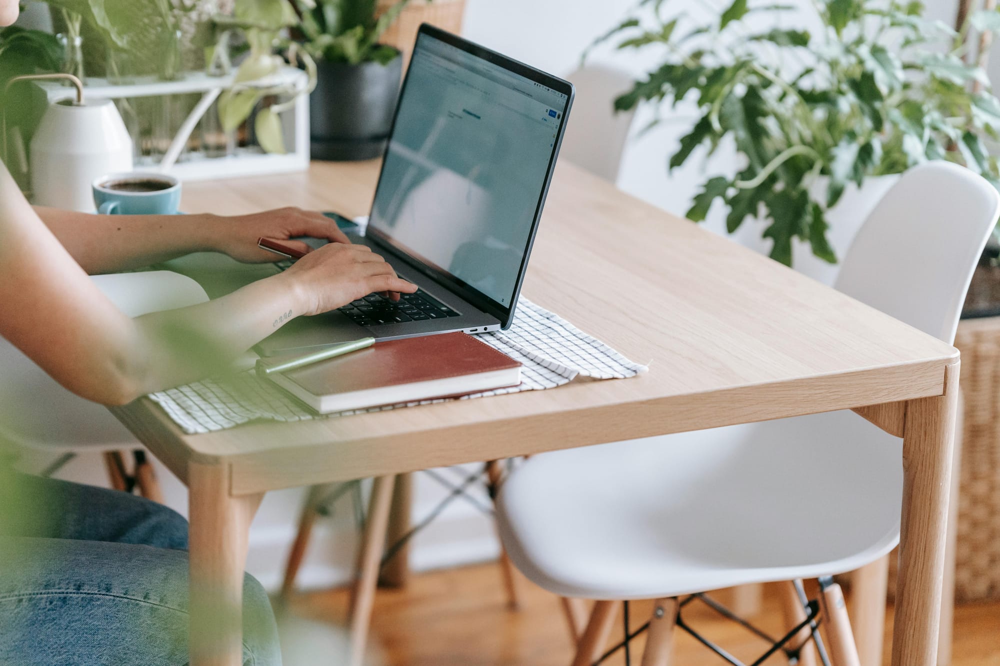 A laptop is placed on a table and a girl is using it